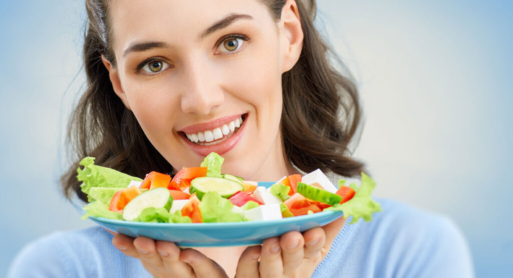 Mujer mostrando un plato de ensalada