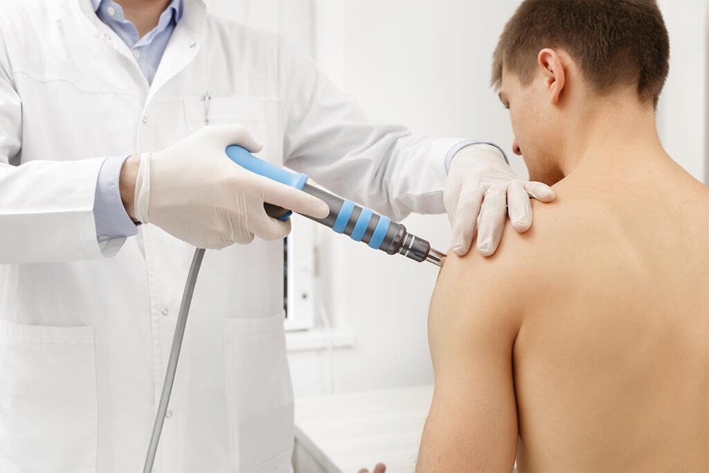 Hombre practicando el tratamiento de Ondas de Choque en el centro de fisioterapia de Crisalud