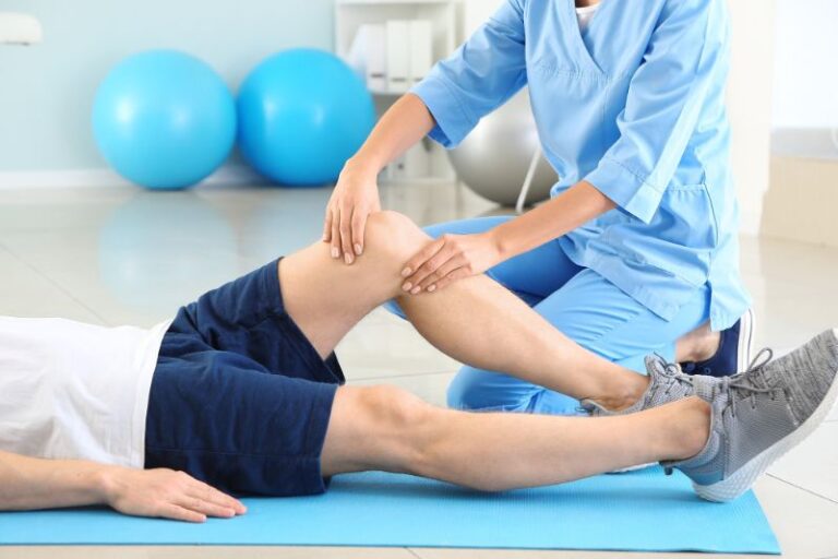 Fisioterapeuta de Crisalud atendiendo la rodilla de un paciente